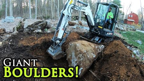 excavating large boudlers with mini excavator|Moving a big boulder with a mini excavator .